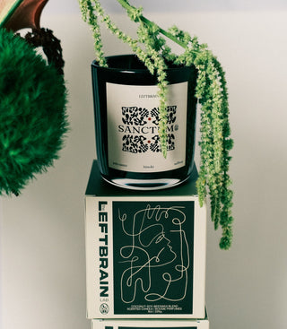 Hand-poured Sanctum Candle on its designed box with green flowers, highlighting its minimalist design and calming home fragrance.