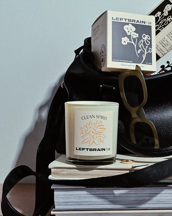 Hand-poured Clean Spirit clean linen-scented candle arranged on books, showcasing its minimalist design and calming home fragrance.